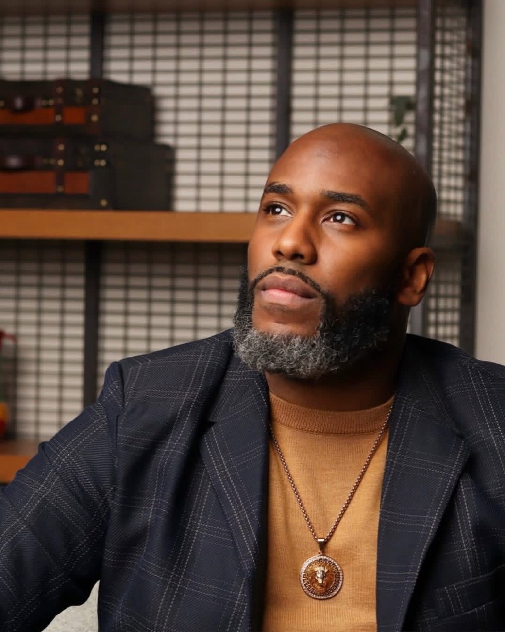 Derrick L. Mercer Jr. in a navy plaid jacket, looking up