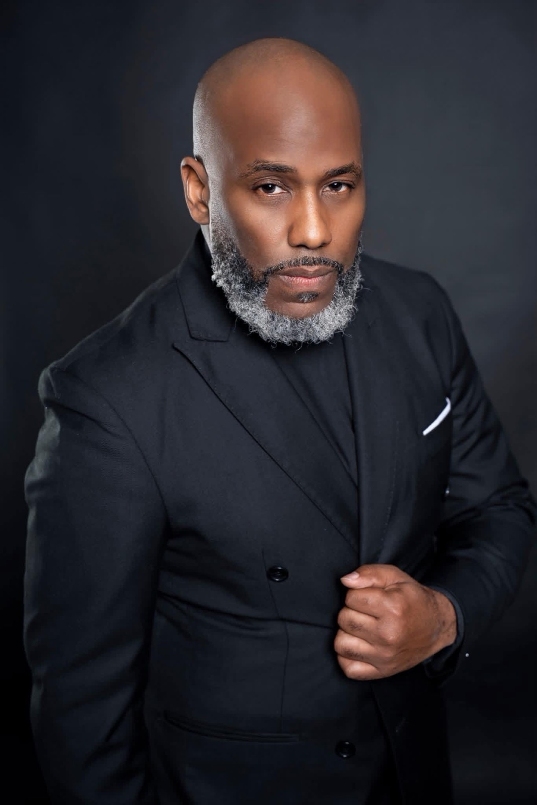 Derrick L. Mercer Jr. in a black suit, direct gaze